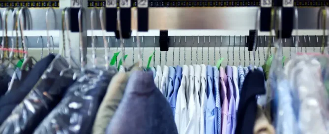 Chemises rangées sur cintres dans un pressing